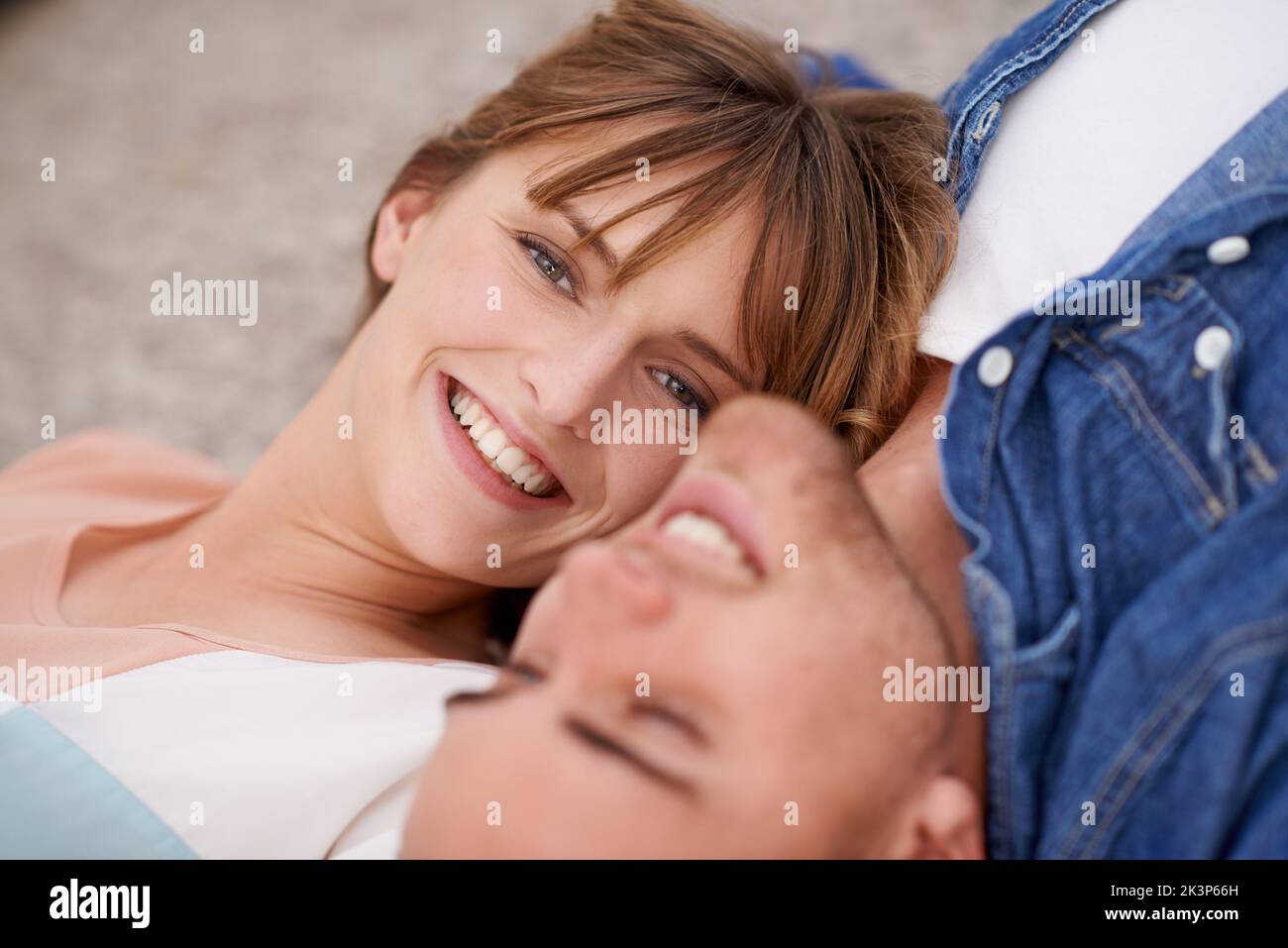 Un petit amour merveilleux. Un jeune couple allongé sur le sol du salon, à proximité avec affection. Banque D'Images