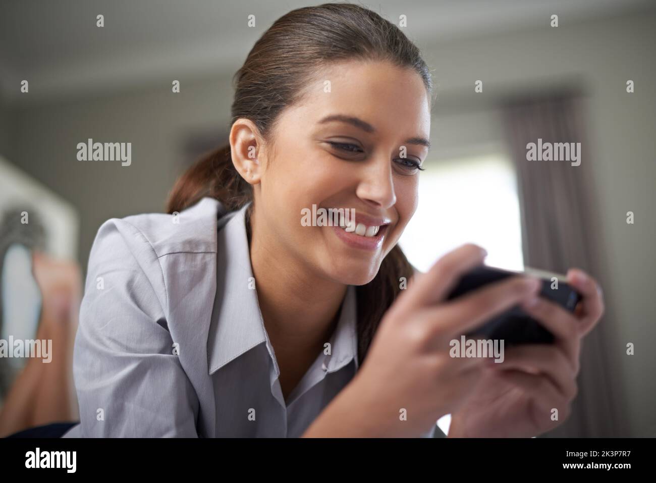 Se mettre en train de rentrer chez elle. Une jeune femme d'affaires tapant un sms à la maison. Banque D'Images