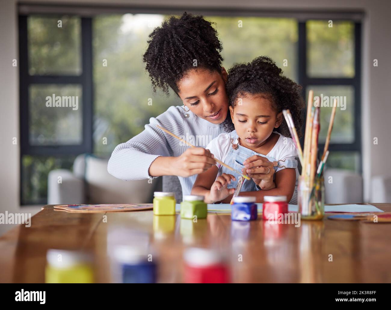 Apprendre, la peinture de mère et d'enfant pour un projet d'art préscolaire avec une jeune maman aidant sa fille à la maison. Jardin d'enfants, amour et créatif Banque D'Images
