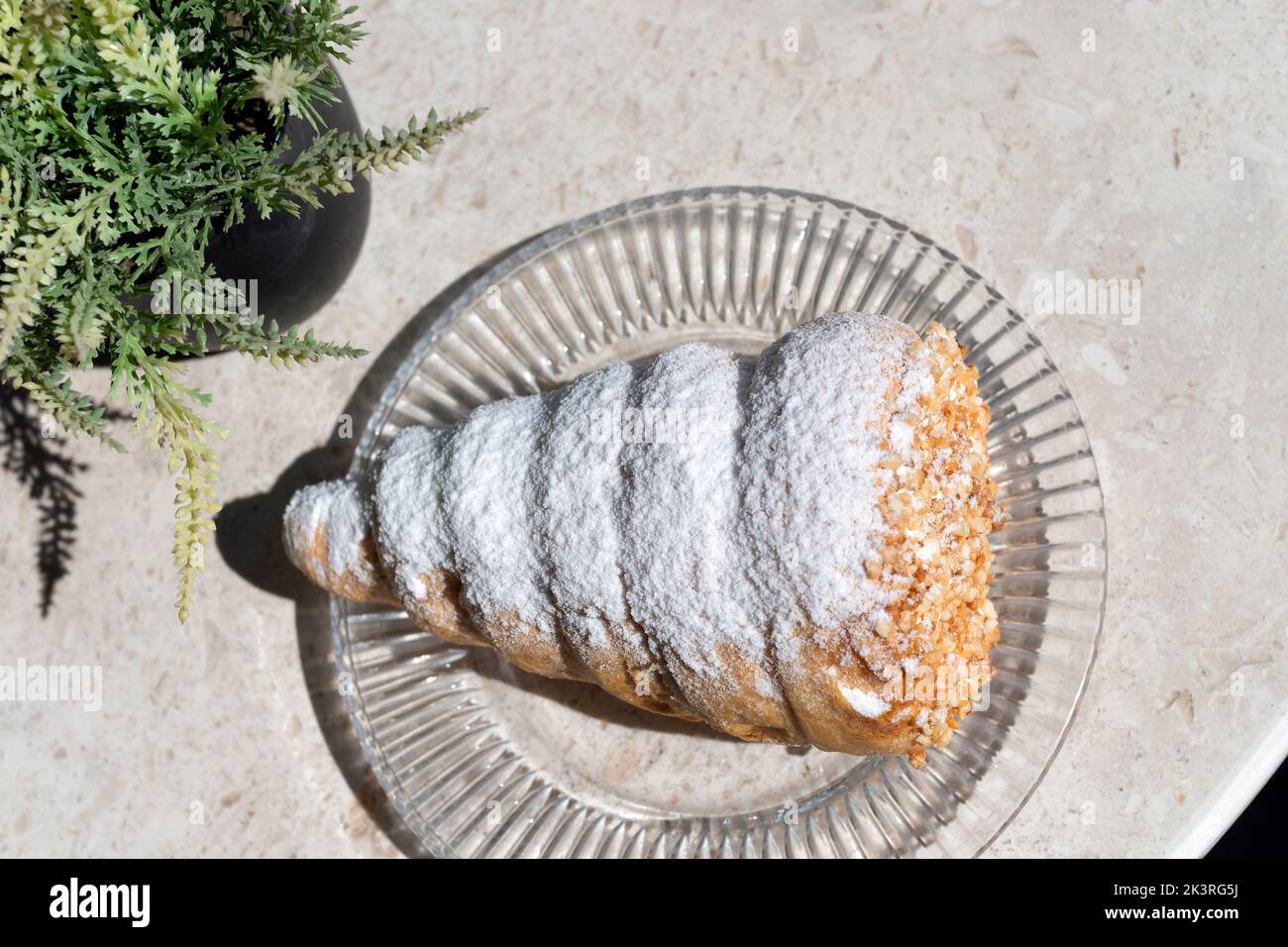 Une grande corne crème fraîche classique. Le gâteau, fait avec une pâte feuilletée, et saupoudré avec du sucre glace et des noix. Le gâteau a une garniture de crème fraîche. Banque D'Images