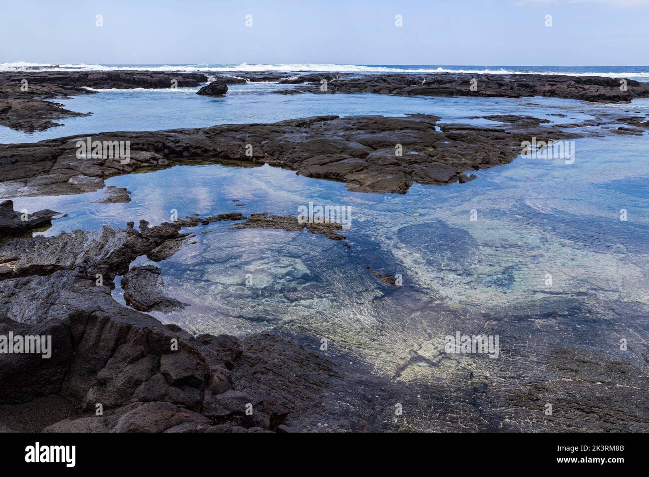 clayette en roche de lave noire et océan le long de la côte au parc national historique de pu'uhonua o honaunau hawaii Banque D'Images