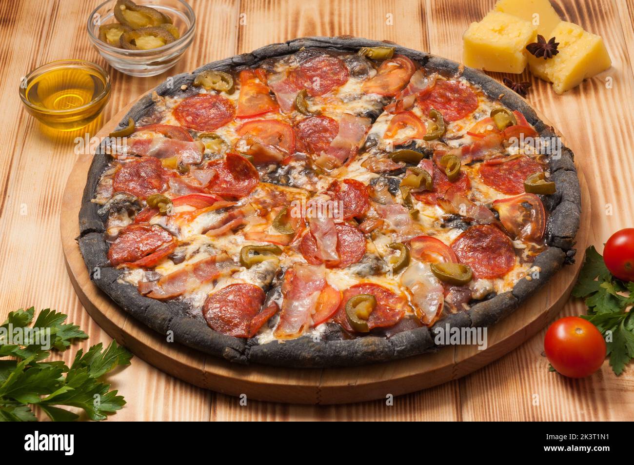 pizza savoureuse avec pepperoni et bacon de jalapeno sur pâte noire Banque D'Images pizza savoureuse avec pepperoni et bacon de jalapeno sur pâte noire Banque D'Images