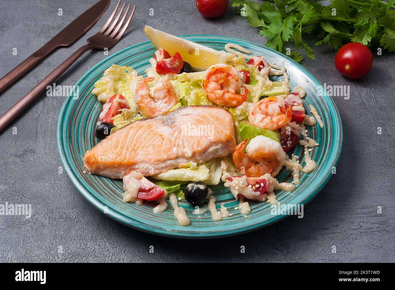 salade savoureuse avec saumon, crevettes et légumes sur fond gris Banque D'Images