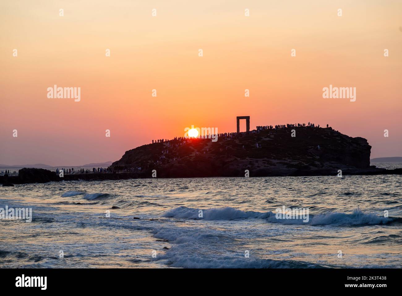 Île de Naxos, coucher de soleil sur le Temple d'Apollon, Cyclades destination Grèce. Les touristes admirent le coucher de soleil de l'îlot de Palatia. Ondulation mer coloré sk Banque D'Images