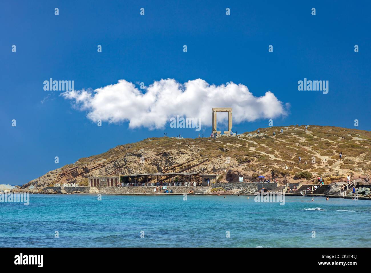 Île de Naxos, Cyclades Grèce. Touristes au Temple d'Apollon, café en bord de mer de l'îlot de Palatia au port. Destination estivale. Banque D'Images