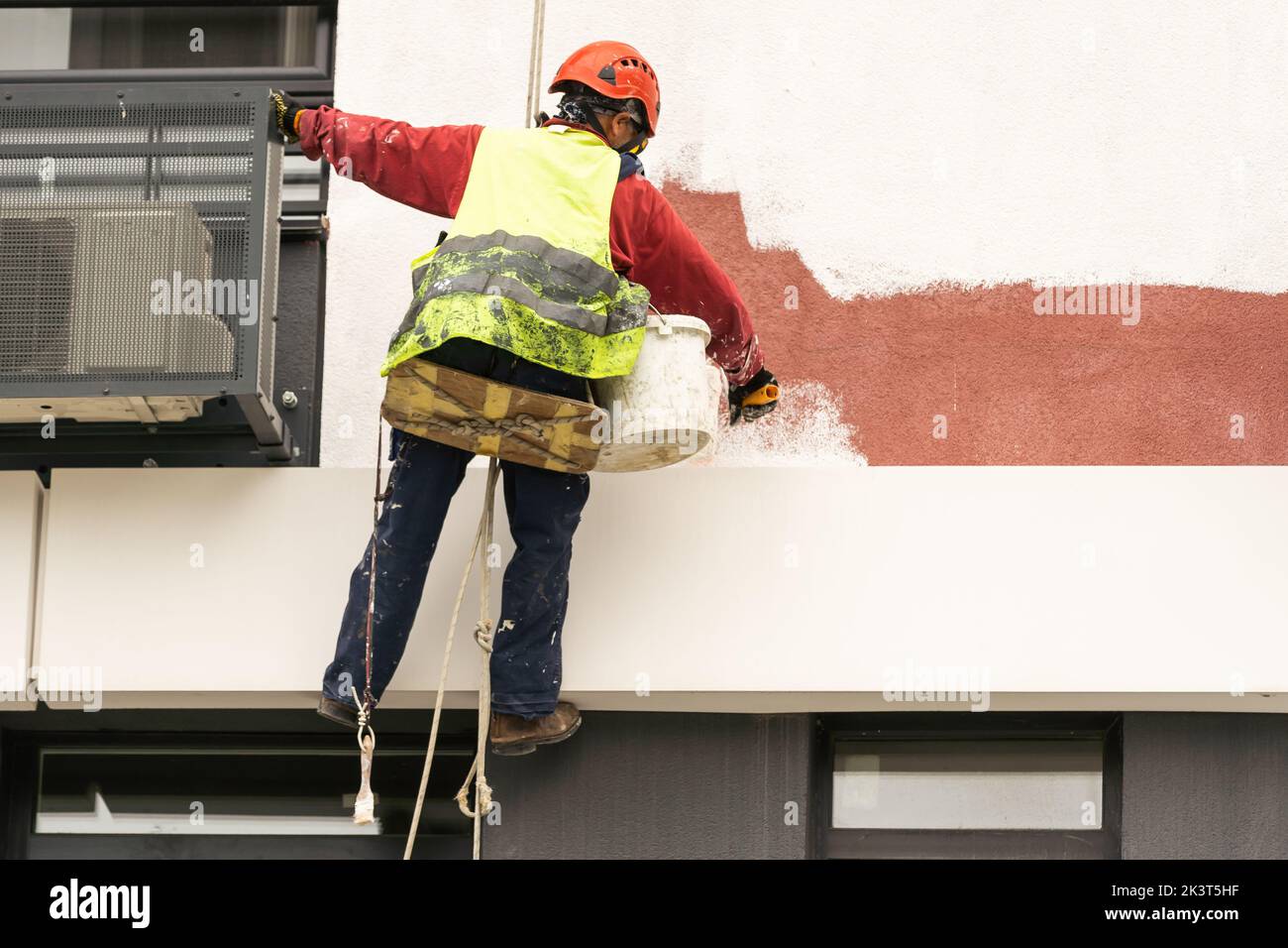 Les peintres-altitude modernisent la façade du bâtiment. Banque D'Images