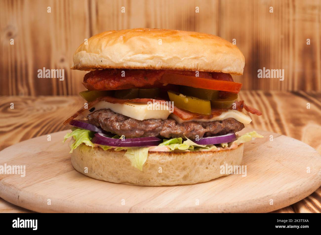 hamburger savoureux avec patty de bœuf, bacon, jalapeno, fromage, tomate et oignon Banque D'Images hamburger savoureux avec patty de bœuf, bacon, jalapeno, fromage, tomate et oignon Banque D'Images