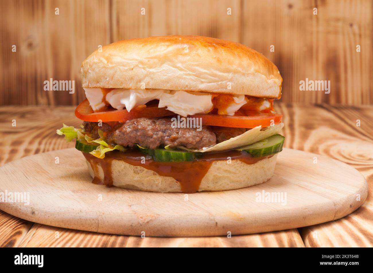 hamburger savoureux avec patty de bœuf, concombres, tomates et fromage à la crème Banque D'Images