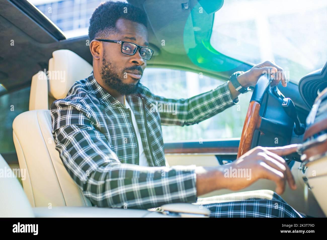 Beau barbu homme assis détendu dans sa voiture nouvellement achetée à l'extérieur Banque D'Images Beau barbu homme assis détendu dans sa voiture nouvellement achetée à l'extérieur Banque D'Images