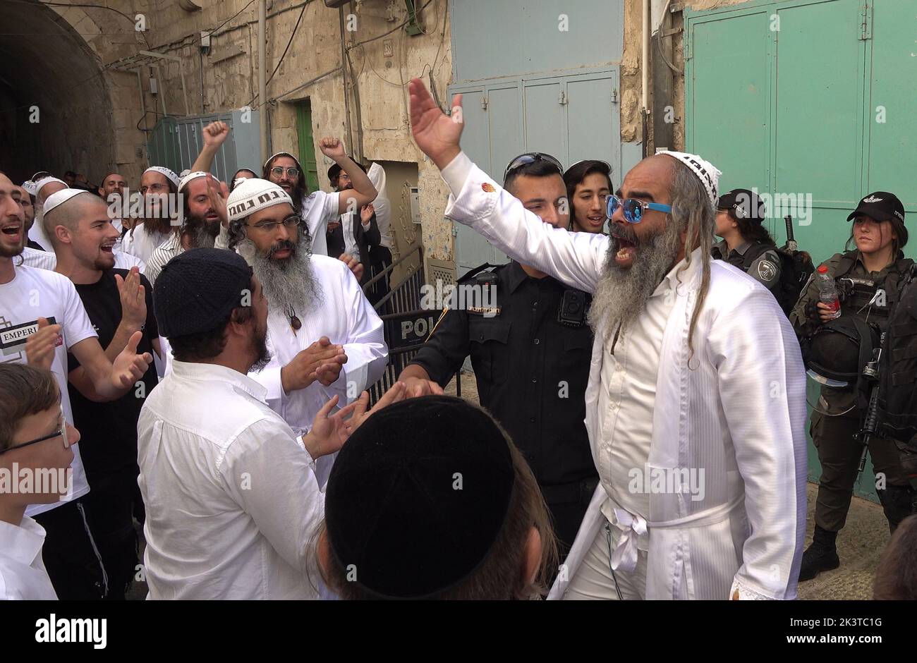 Les membres des forces de sécurité israéliennes se tiennent en garde tandis que les juifs religieux chantent et dansent après leur visite au mont du Temple dans la rue Chain Gate dans la vieille ville de 27 septembre 2022, à Jérusalem, en Israël. Banque D'Images