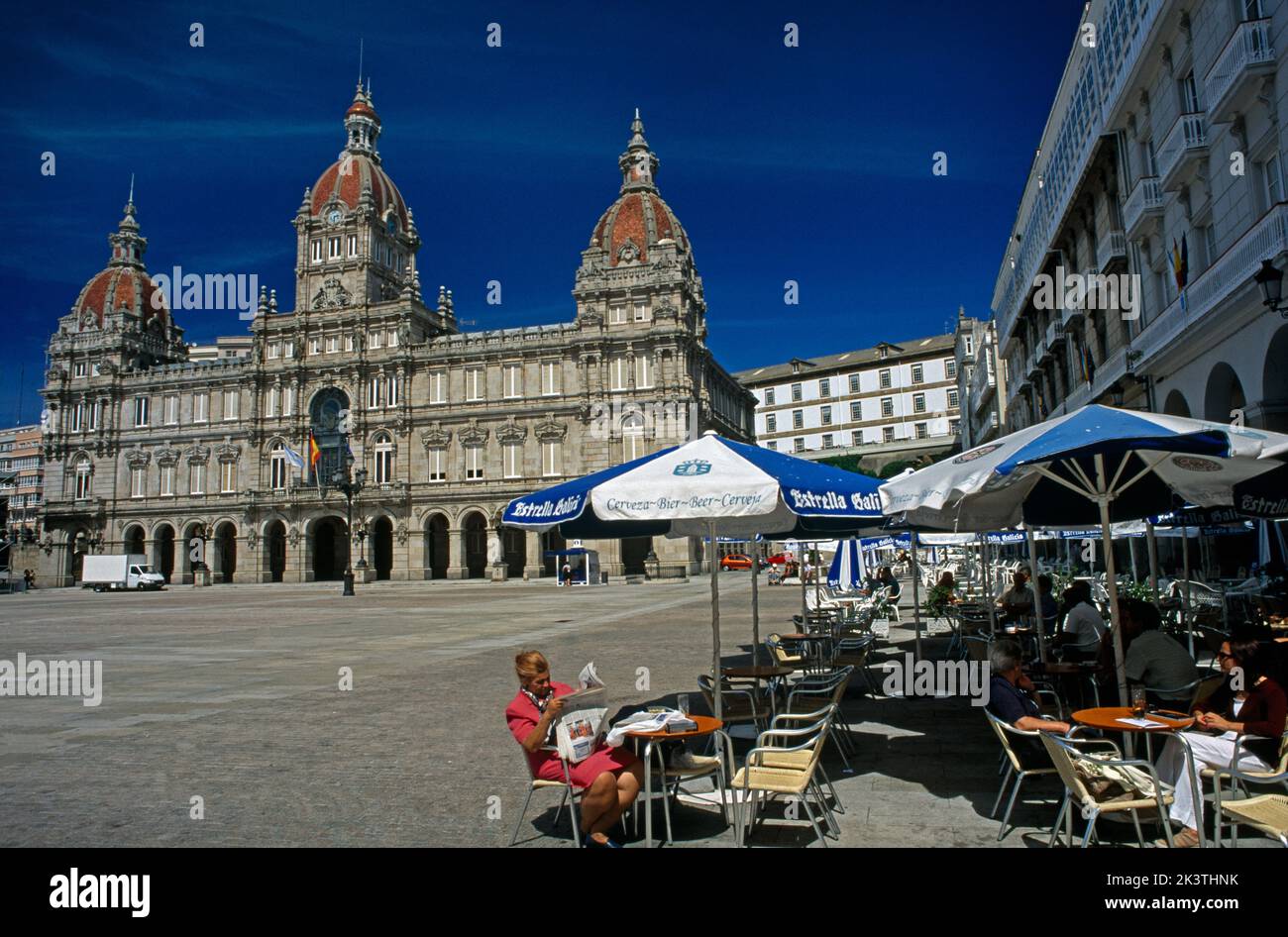 A Coruna Galice Espagne Plaza de Maria Pita - Femme au café lecture du journal près de l'Hôtel de ville Banque D'Images