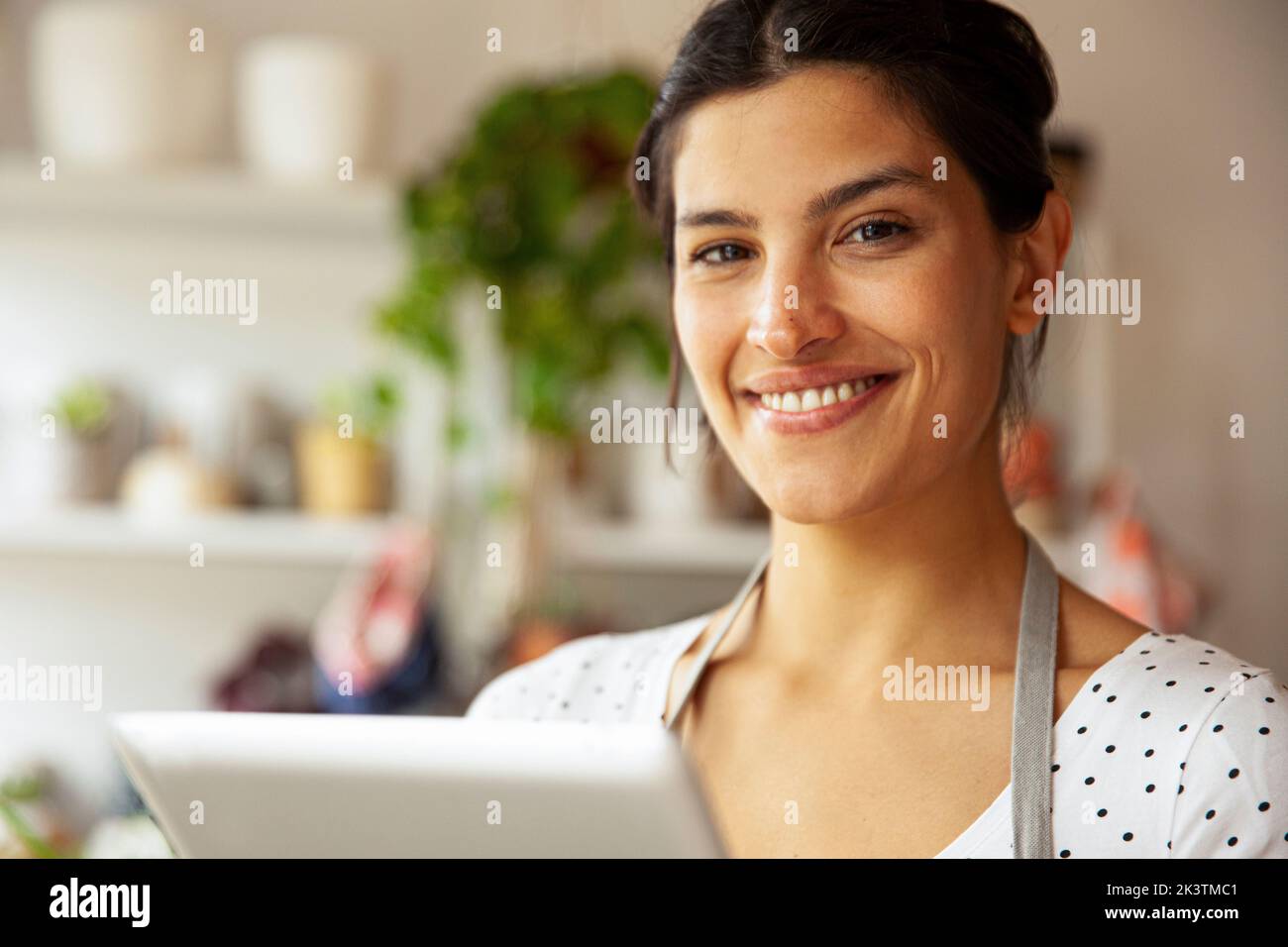 Jeune femme entrepreneur adulte souriant à la caméra Banque D'Images