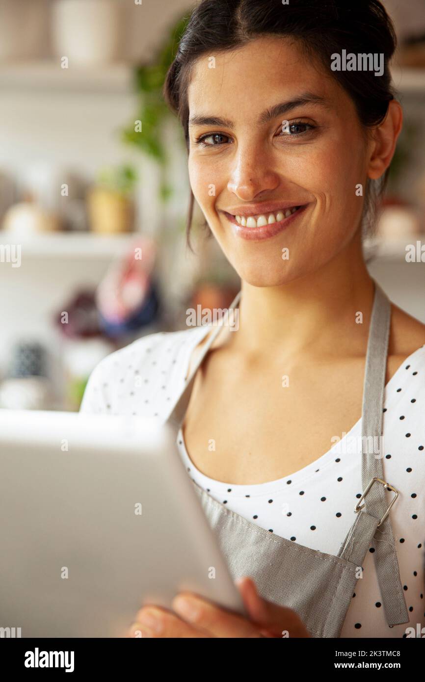 Jeune femme entrepreneur adulte souriant à la caméra Banque D'Images