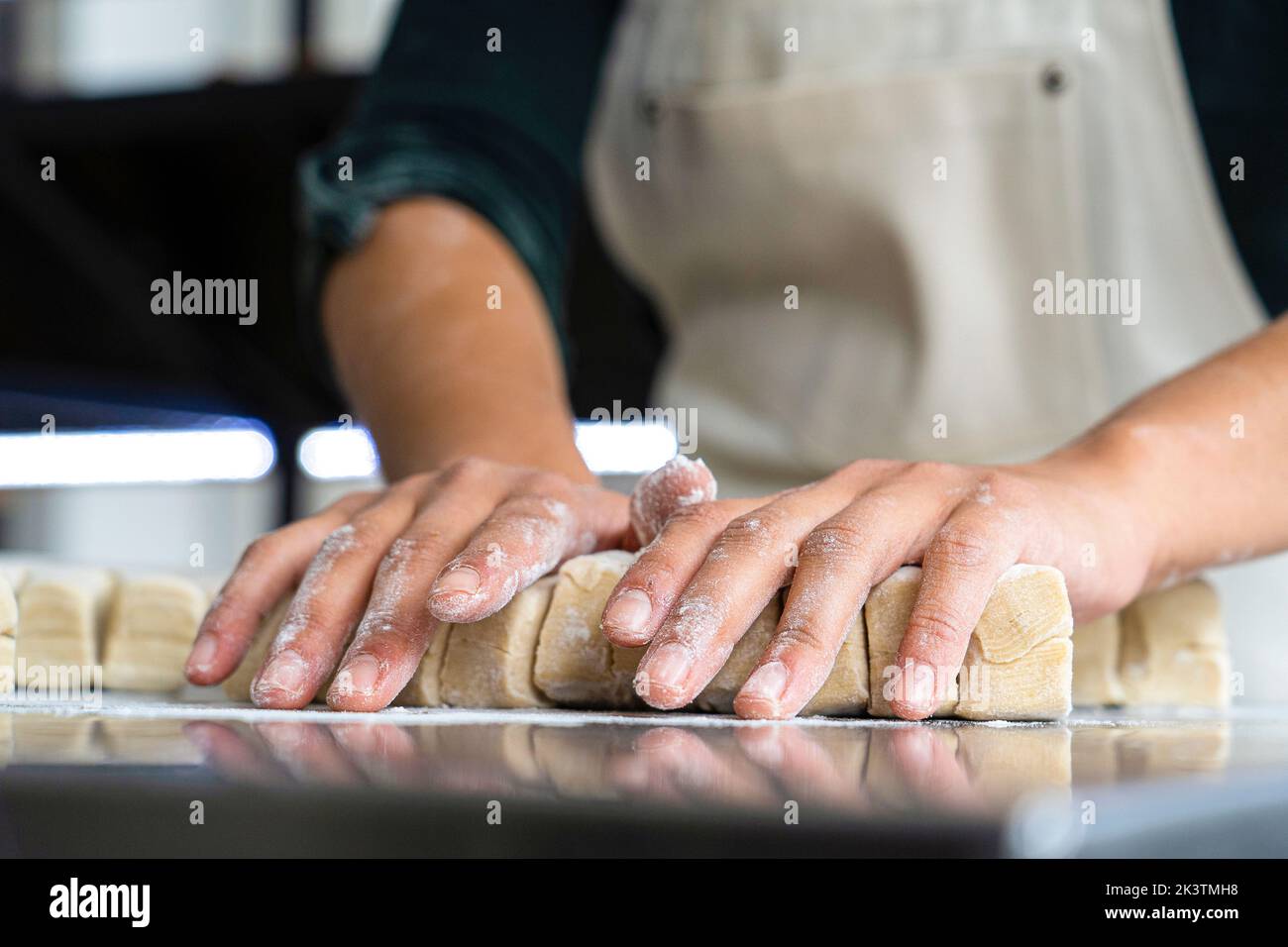 Vue à angle bas de la pâte à pétrir pour les mains des boulangeuses Banque D'Images