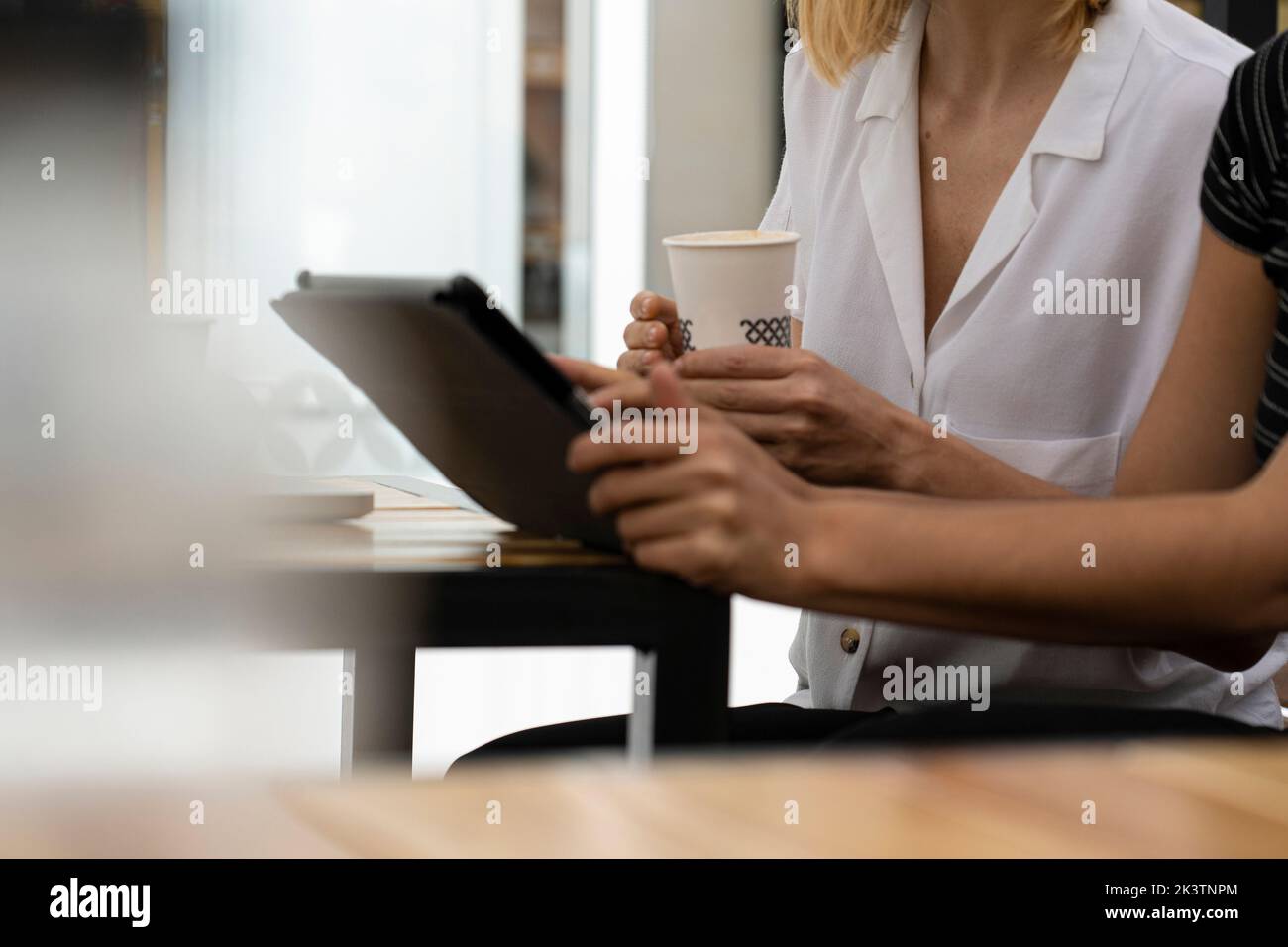 Mi-shot des mains des femmes entrepreneurs tout en travaillant sur un ordinateur portable et une tablette numérique Banque D'Images