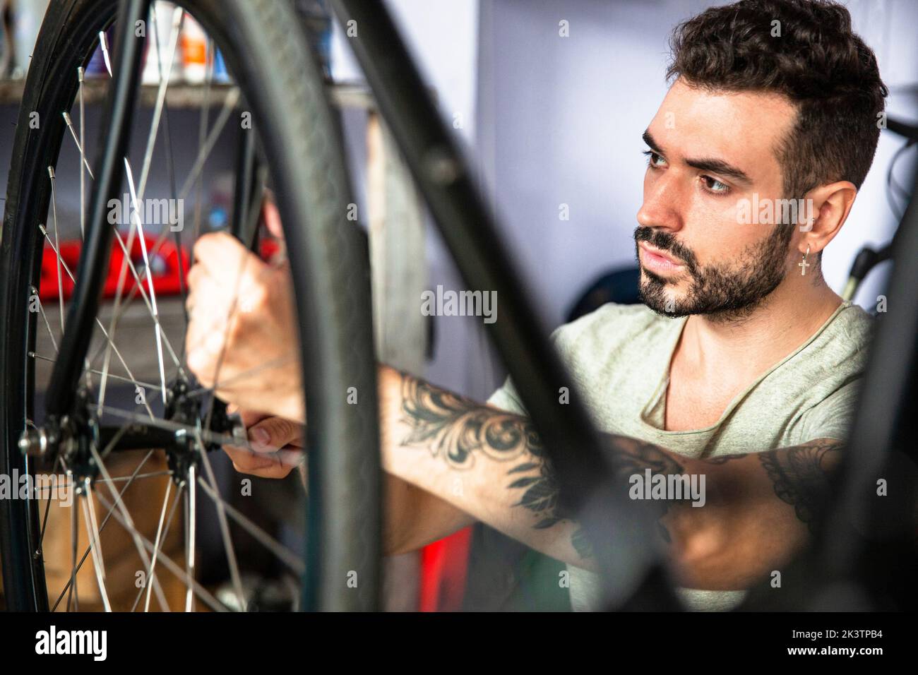 Jeune homme mécanicien de réparation de vélo dans l'atelier Banque D'Images