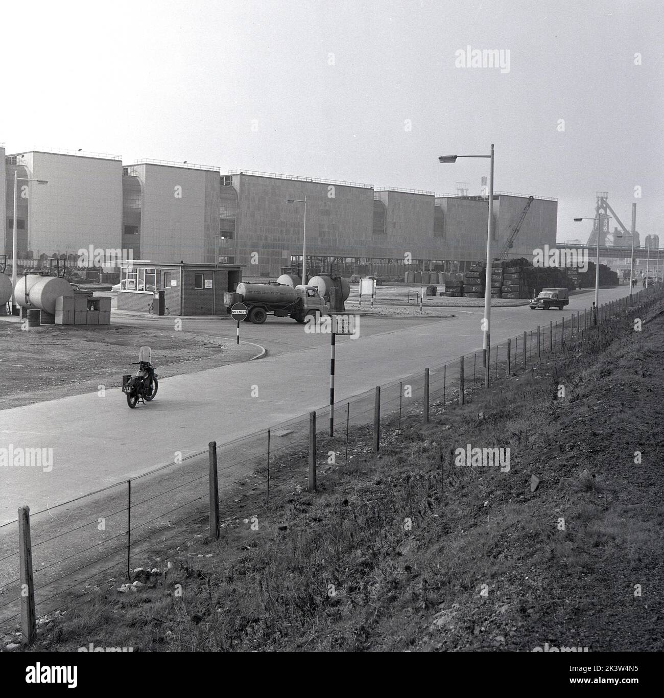 Années 1950, historique, une vue de East Road à l'usine de fabrication géante de la Steel Company of Wales d'Abbey Works à Port Talbot, pays de Galles, Royaume-Uni, montrant de grands bâtiments et un arrêt de bus SCOW. Banque D'Images