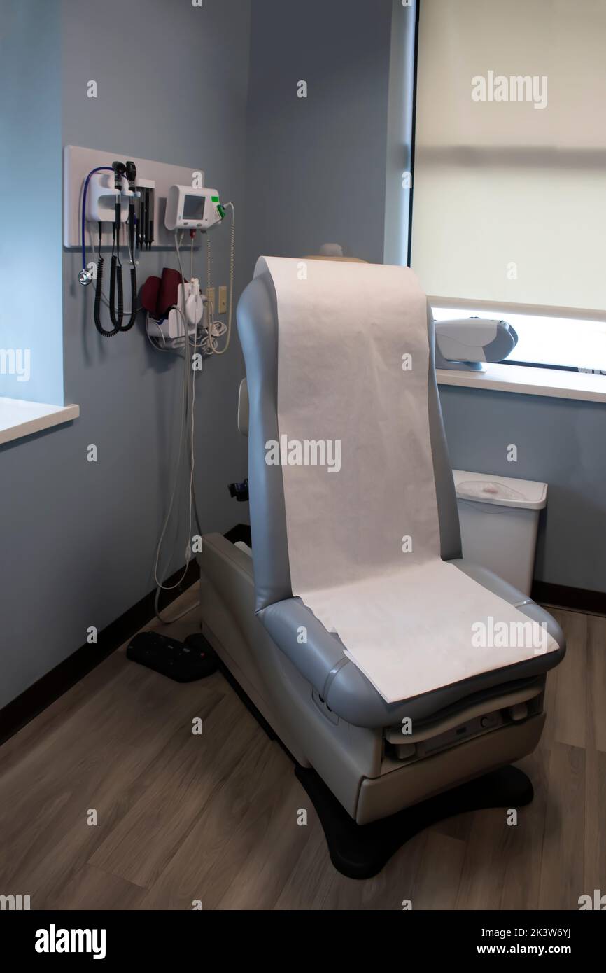 chaise de patient électrique avec rouleau de papier hygiénique blanc jetable et mur des dispositifs médicaux et de l'équipement pateint assis et salle d'examen Banque D'Images