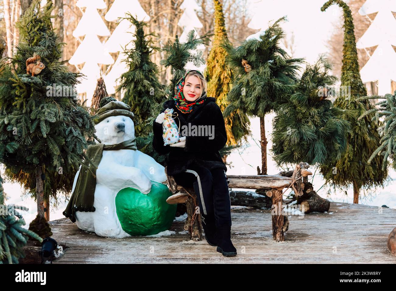 Belle femme ukrainienne dans un foulard national avec un bonhomme de neige entre ses mains Banque D'Images