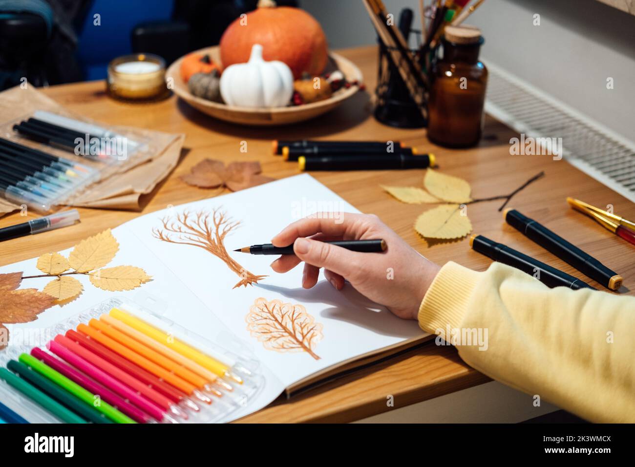 Idées de peinture d'automne, peinture d'automne facile pour adultes, pour débutants. Scènes d'automne. Portrait sans visage d'une femme dessinant des arbres d'automne avec des marqueurs. Banque D'Images