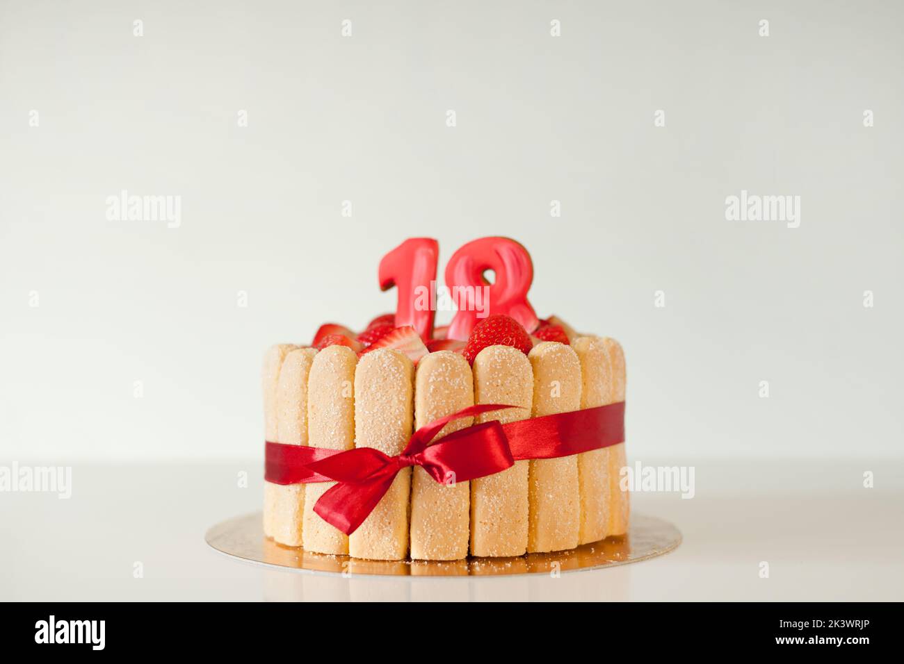 Gâteau délicieux avec des chiffres sur fond gris, espace pour le texte. Fête d'âge - anniversaire 18th. Banque D'Images