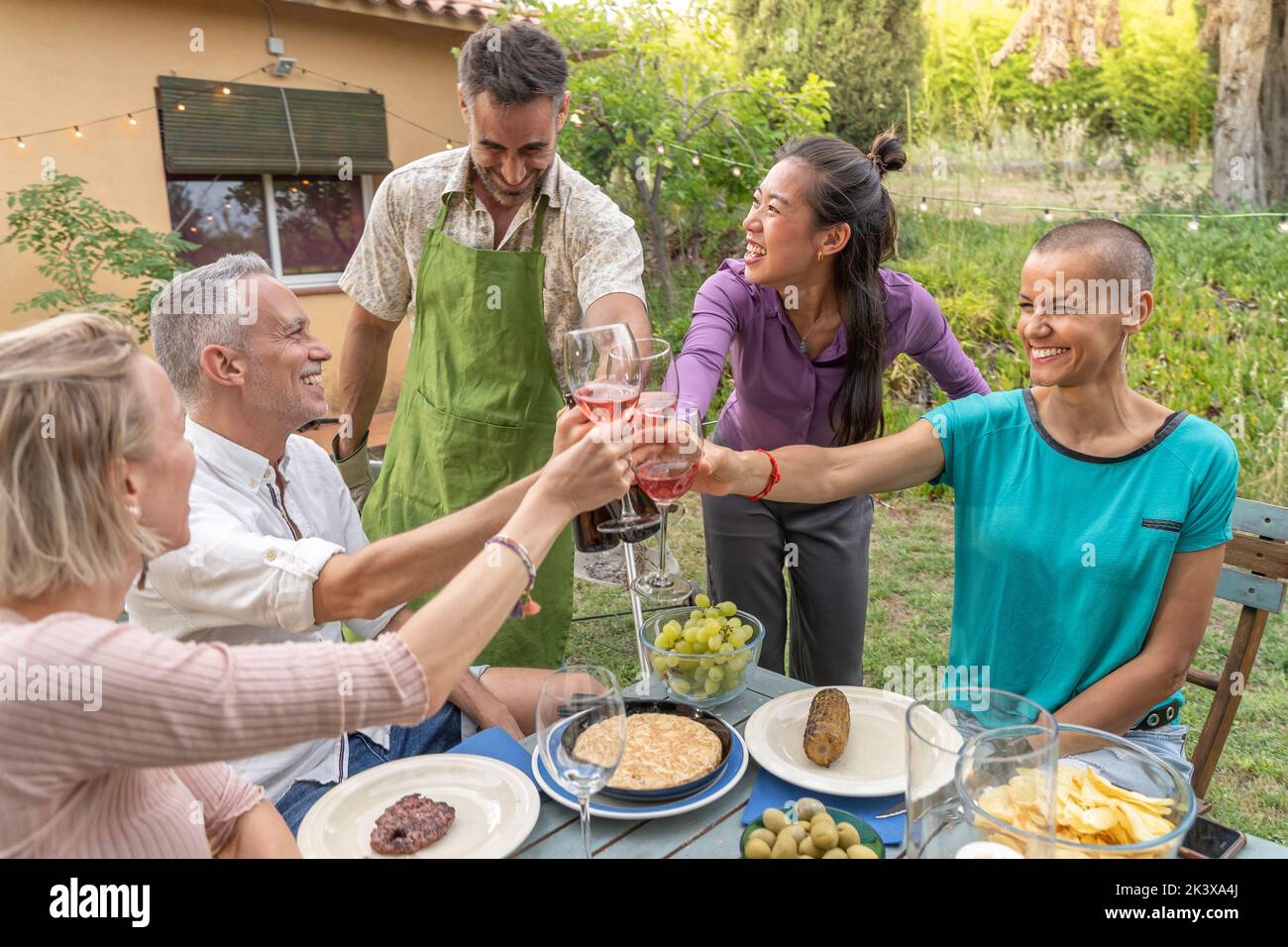 Une bonne dégustation en famille avec un beau sourire autour de la table dans le patio de la maison. Banque D'Images