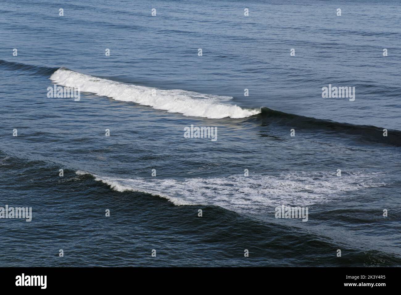 Les vagues se déferlent et se crêtes avant d'atteindre le rivage. Banque D'Images