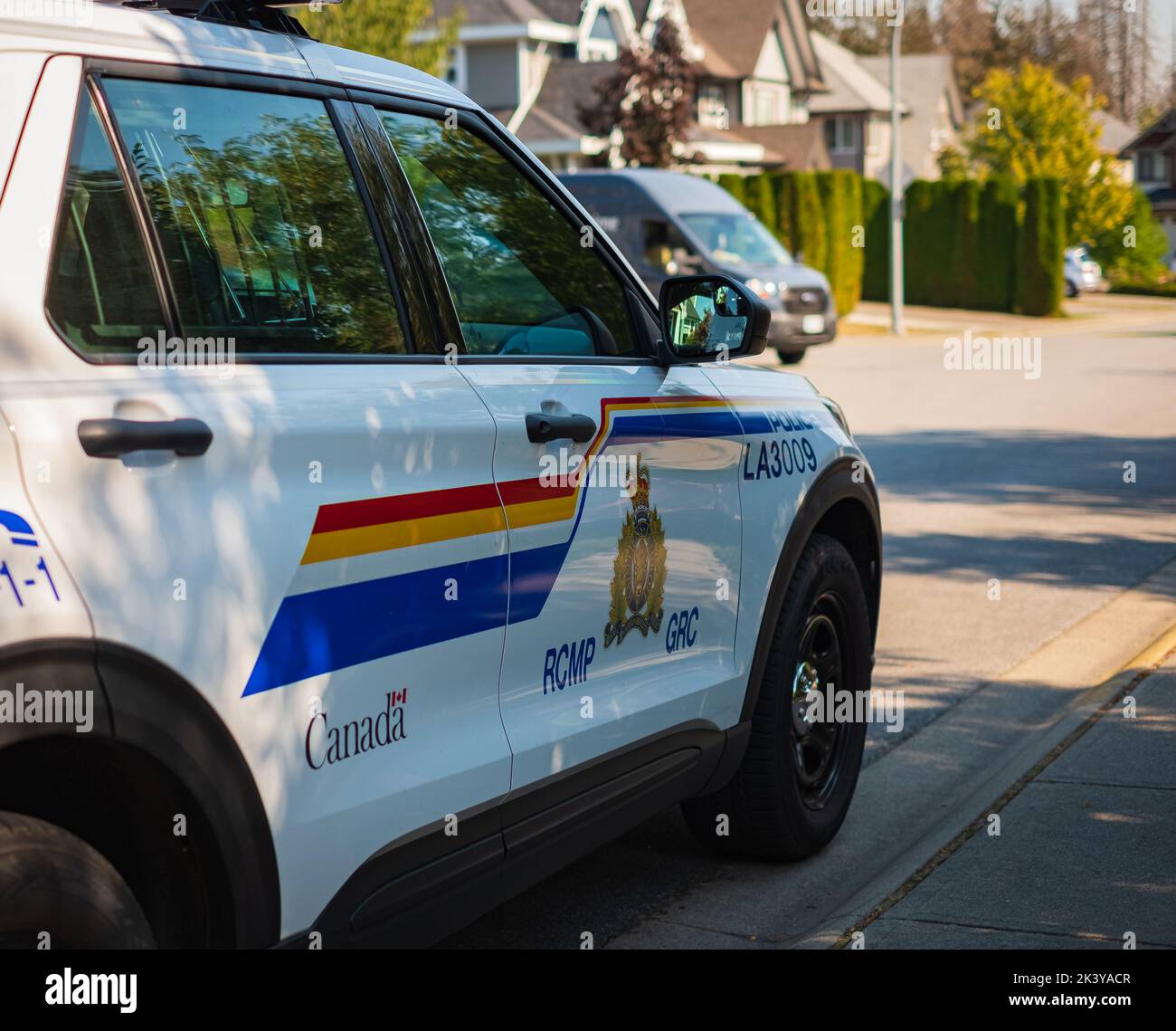 Véhicule de la GRC arrêté dans une rue. Vue rapprochée de la voiture de police de la GRC de Vancouver. Le logo de la porte d'une croisière blanche de la Gendarmerie royale du Canada Banque D'Images