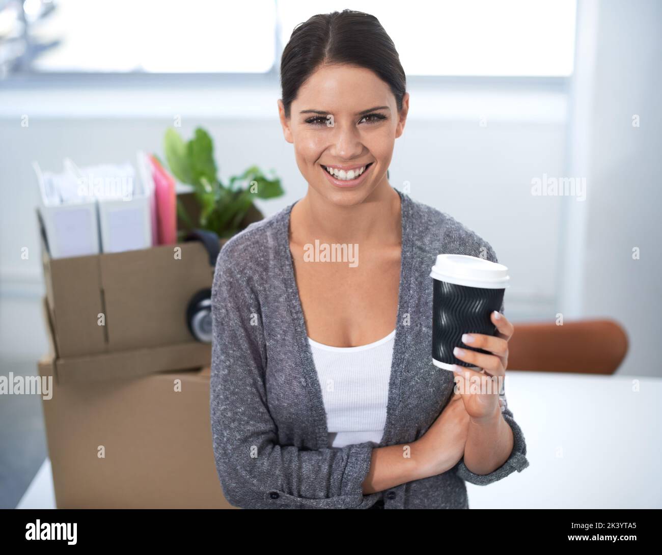 Nouveaux débuts de travail. Portrait d'un jeune employé de bureau qui boit un café tout en se déplaçant dans un nouveau bureau. Banque D'Images