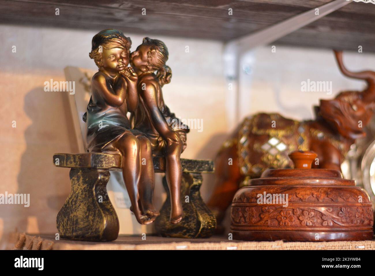 Statue avec deux enfants sur un banc. La petite fille embrassa le garçon sur la joue. Banque D'Images