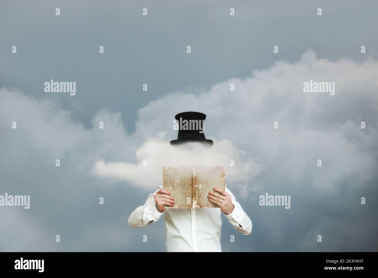 lecteur surréaliste lisant un livre dans les nuages qui cache son visage Banque D'Images