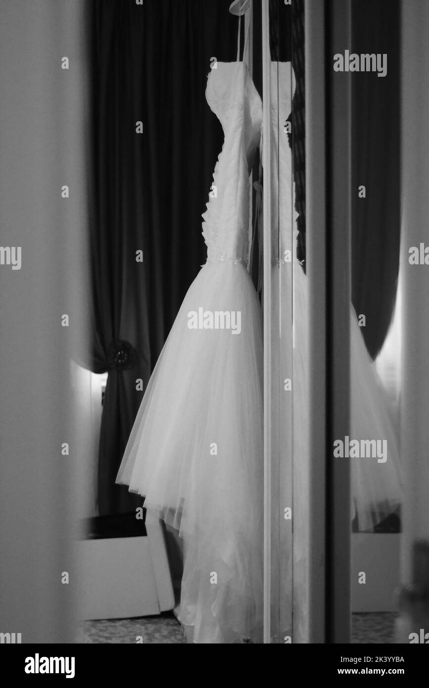 Robe de mariage accrochée au mobilier. Photographie en noir et blanc. Banque D'Images