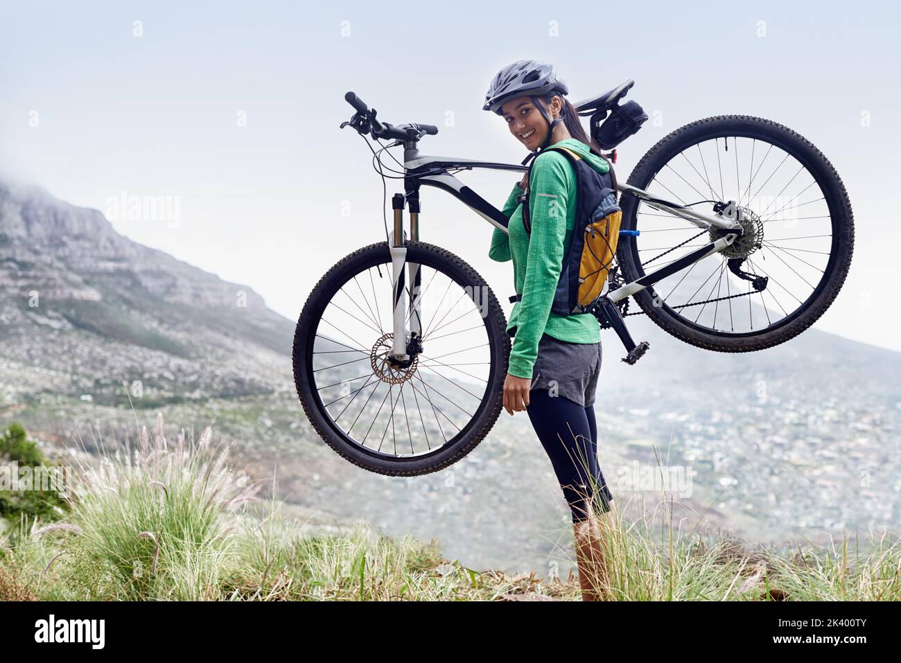 Shes un cavalier aventureux. Une jolie jeune femme portant son vélo de montagne. Banque D'Images