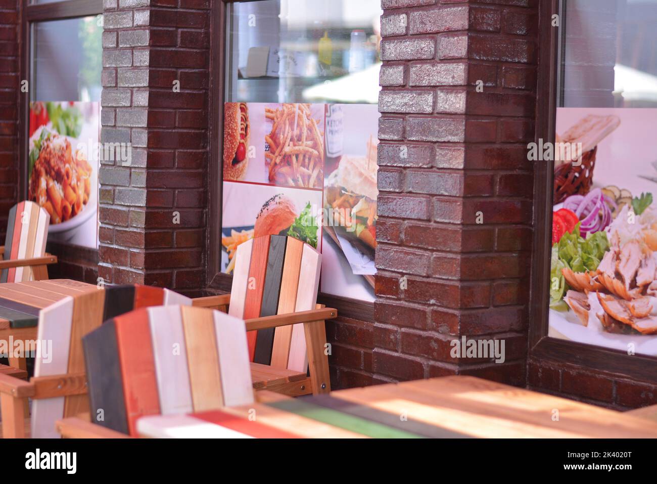 Chaises et tables en bois de couleur. Terrasse d'un restaurant de restauration rapide. Banque D'Images