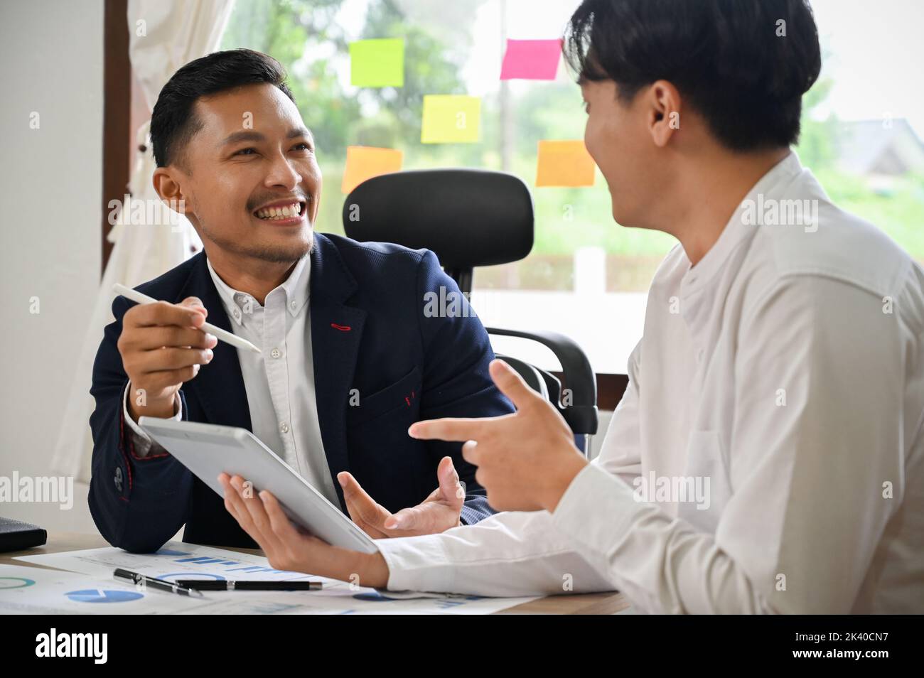 Deux hommes d'affaires asiatiques ou des hommes d'affaires aiment discuter, partager des idées d'affaires tout en travaillant ensemble sur leur projet. Banque D'Images
