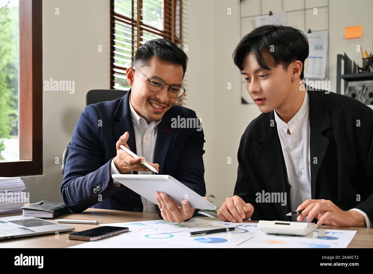 Deux hommes d'affaires asiatiques professionnels et intelligents ou des analystes financiers masculins discutent et travaillent ensemble sur leur plan d'investissement financier. Banque D'Images