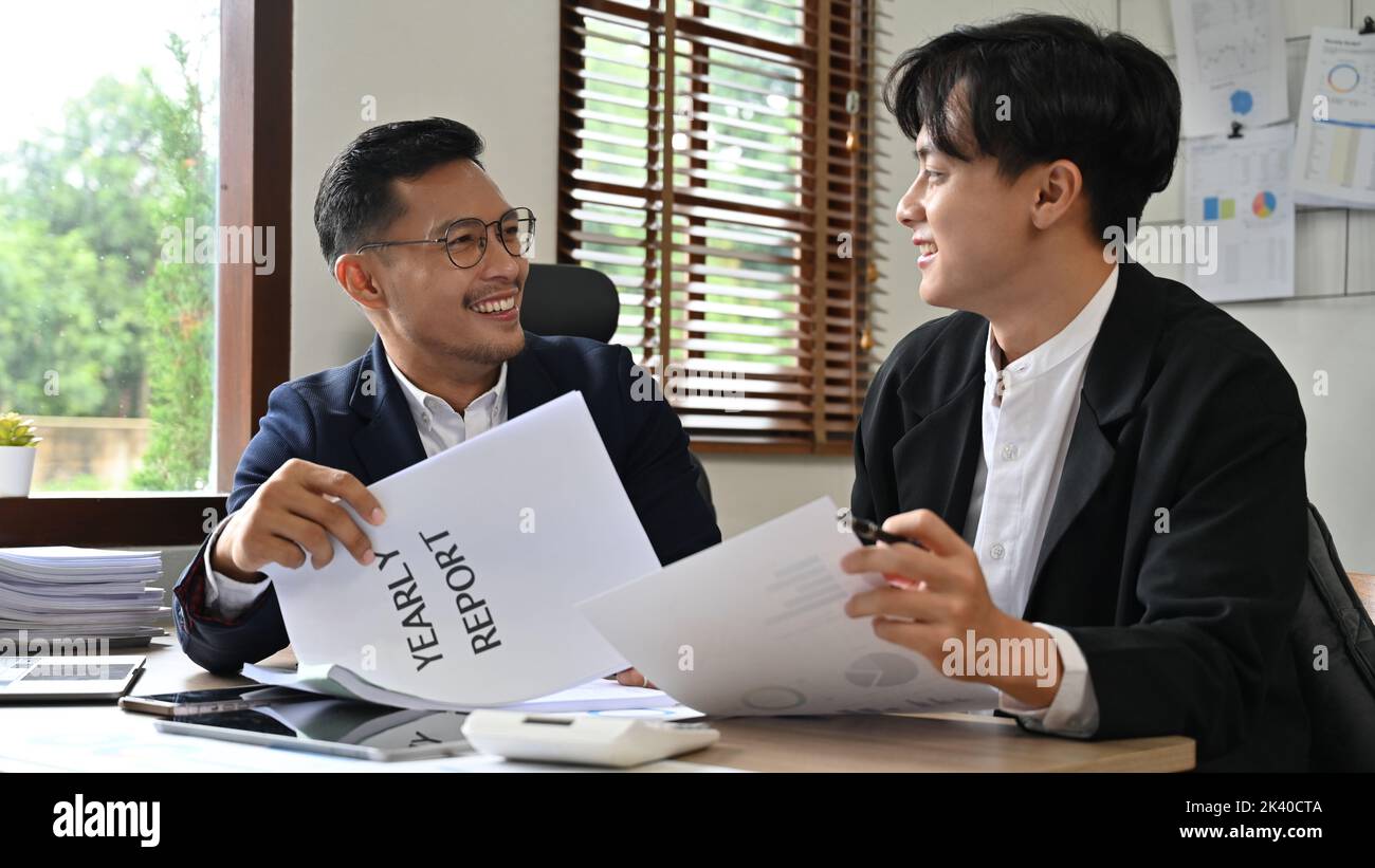 Homme d'affaires asiatique professionnel travaillant et faisant un rapport financier annuel avec son collègue au bureau. Banque D'Images