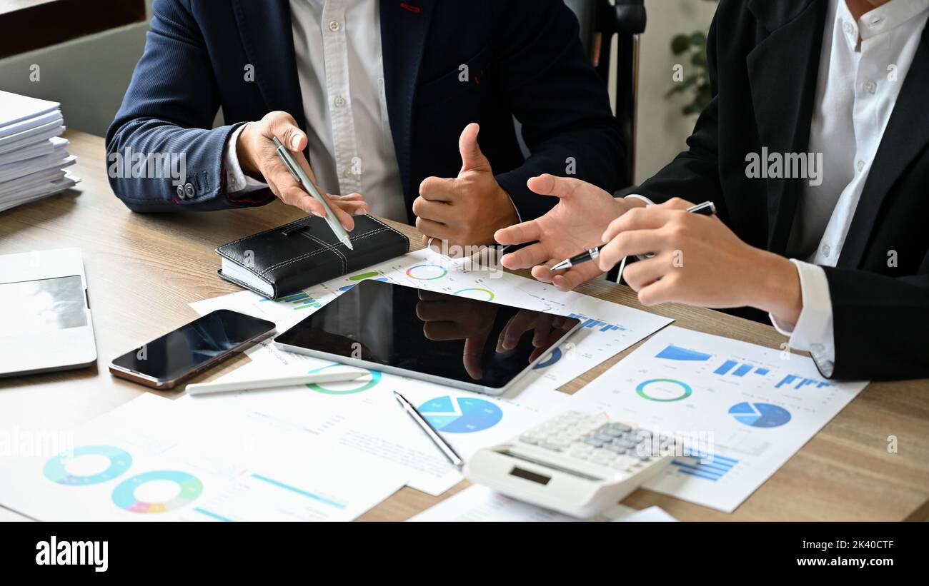 Deux hommes d'affaires asiatiques professionnels et intelligents ou des analystes financiers masculins qui travaillent et discutent de leurs données financières sur le rapport ensemble dans la réunion Banque D'Images