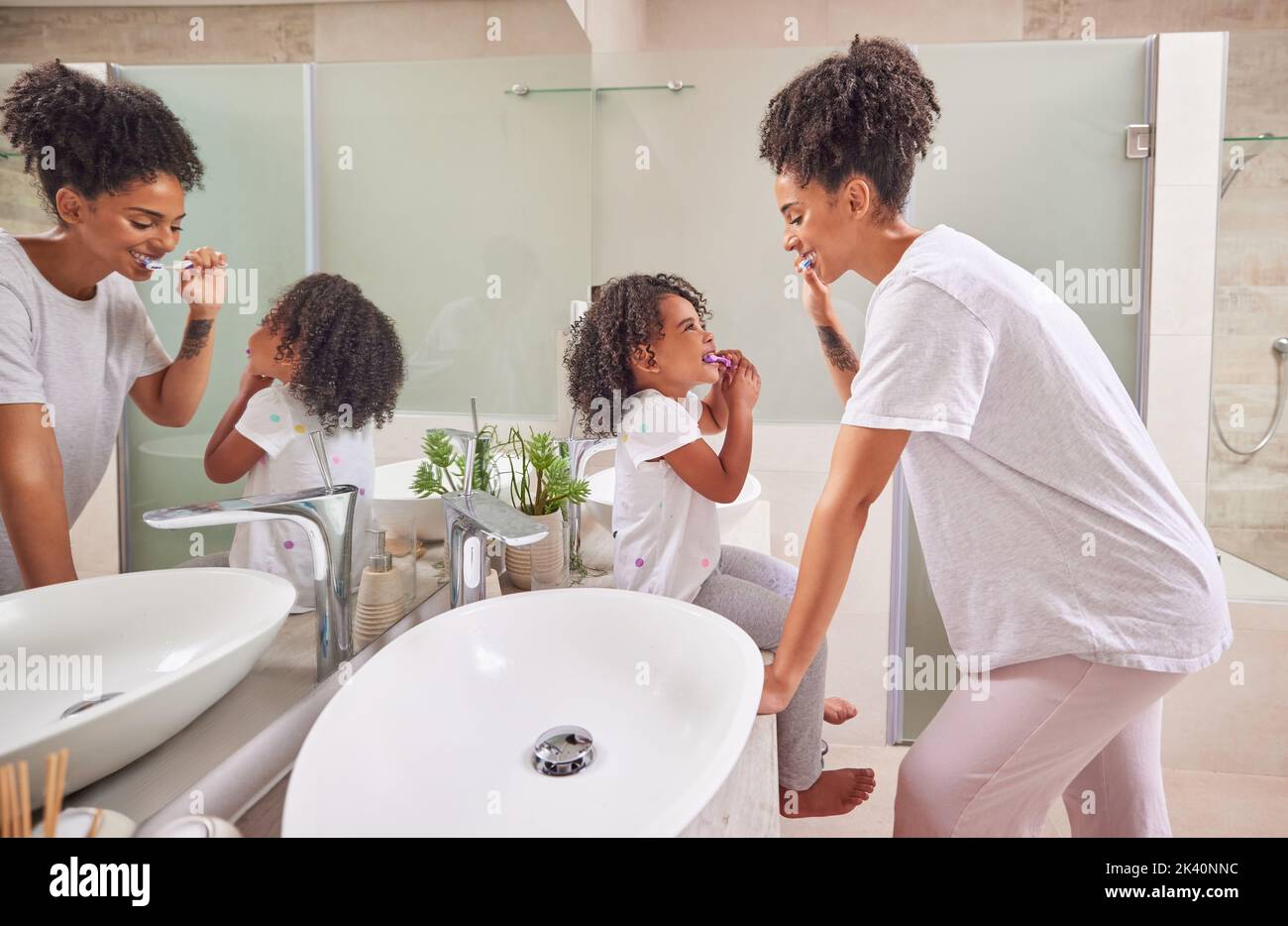 Enfant, dentaire et brosse à dents avec une fille et sa mère se brossant les dents ensemble dans la salle de bains de leur maison. Famille, hygiène et orale avec un Banque D'Images