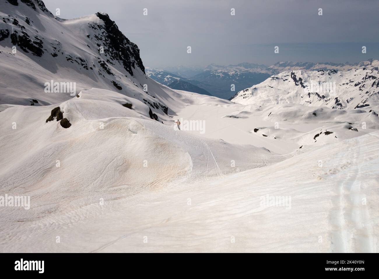 Chamonix, France - 27 mars 2022 : un seul skieur d'arrière-pays sur une crête enneigée après la tempête de poussière de sable du Sahara surplombant la vue d'hiver Banque D'Images