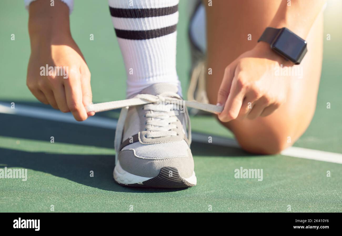 Un joueur de tennis fixe des chaussures avant un match sur le court de tennis, prêt à gagner. Une femme sportive a noué un lacets de chaussures avant le match de tennis. Formation Banque D'Images