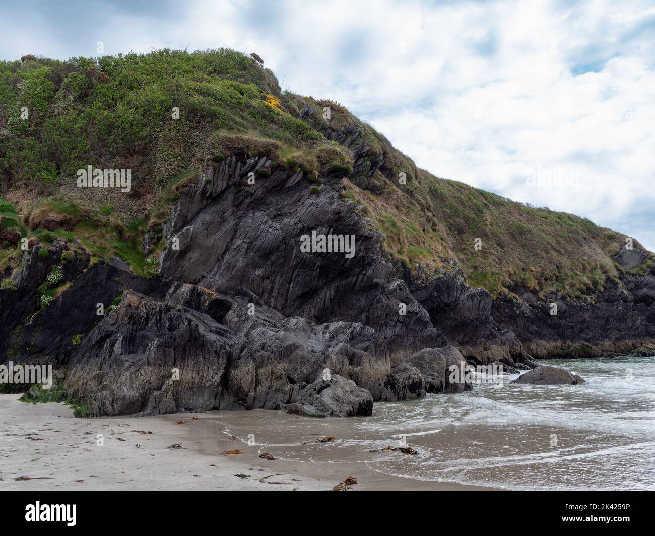 Falaises abruptes à Warren Beach. Beau ciel nuageux. La pittoresque côte irlandaise. Nature de l'Irlande, formation rocheuse sur la rive de la mer. Banque D'Images