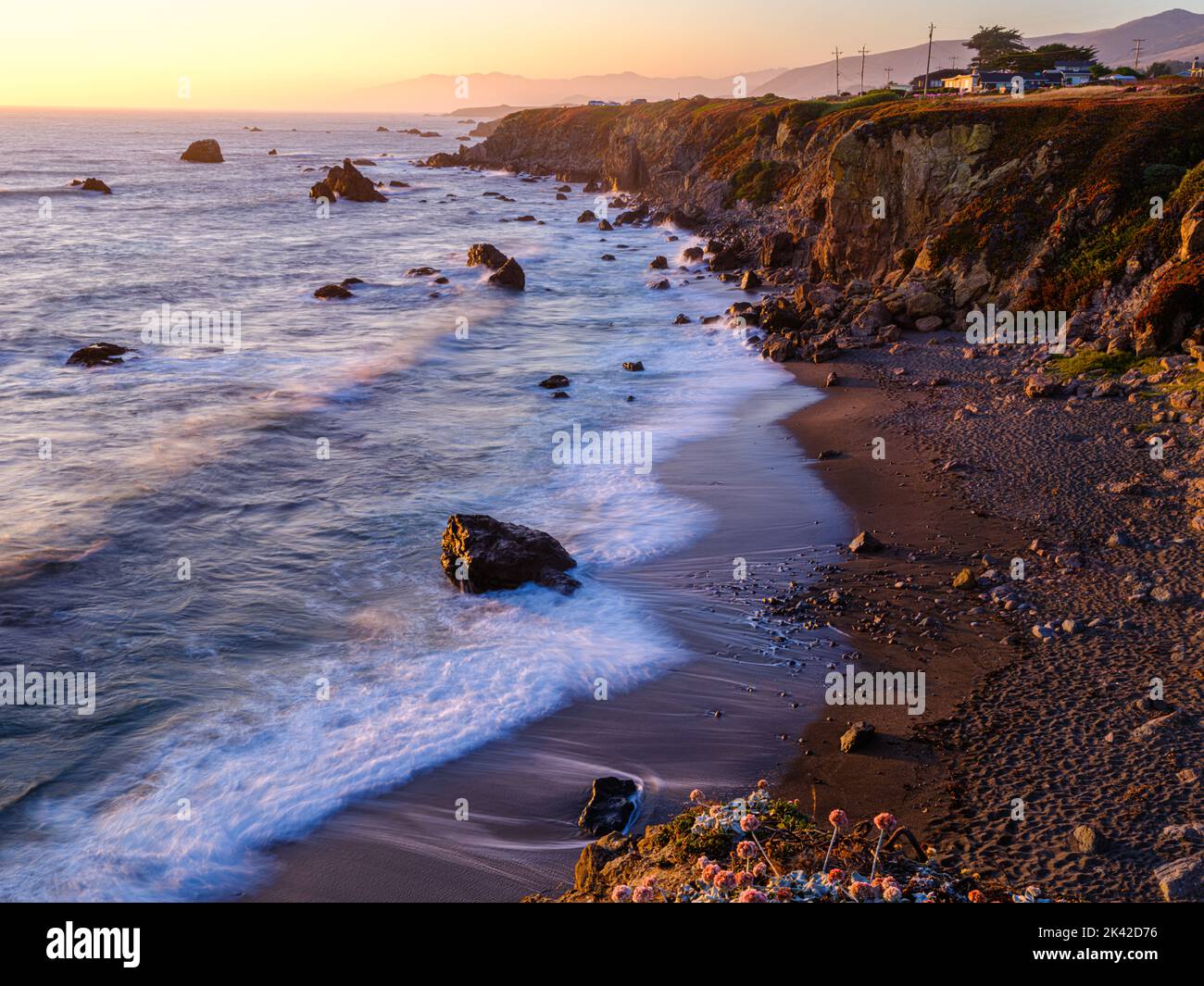 Une vue romantique le long du rivage côtier de la baie de Bodgea ; vagues baignées de soleil au coucher du soleil. Banque D'Images