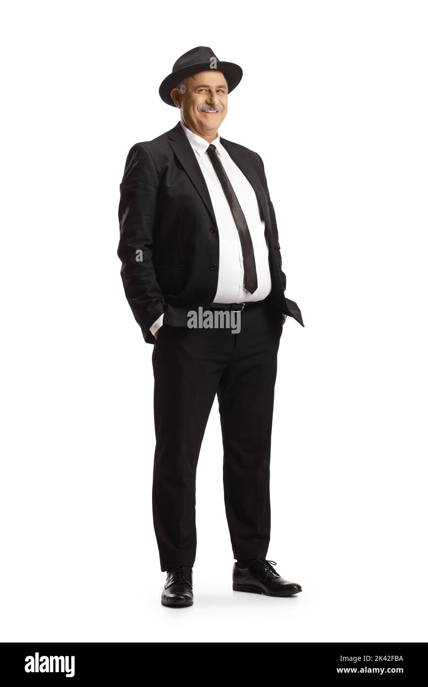 Élégant homme mature en costume noir et cravate portant un chapeau fedora isolé sur fond blanc Banque D'Images
