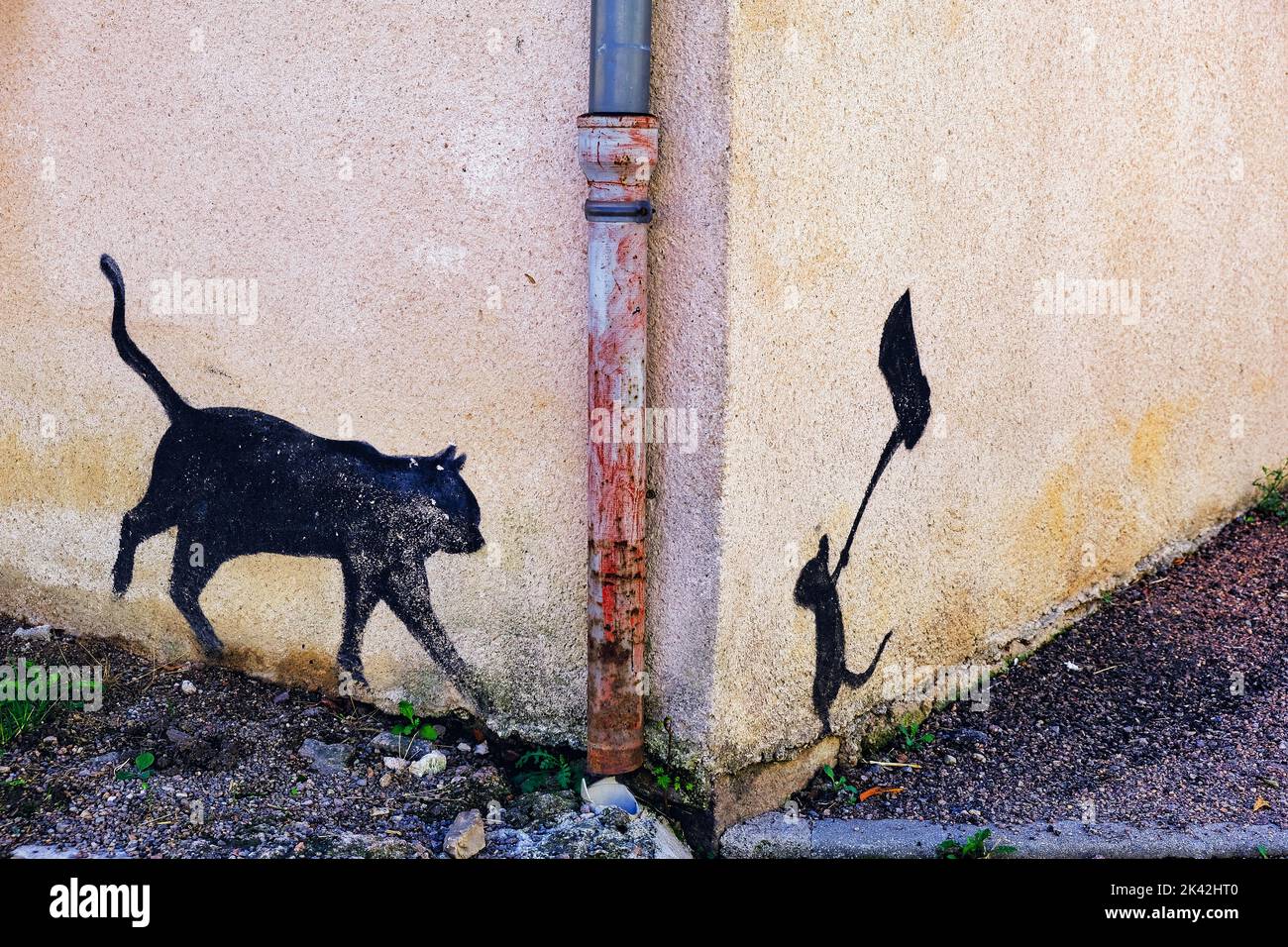 Silhouettes d'une souris ambuer un chat peu méfiant avec une hache, peint au coin d'une maison à Dun-les-places, département de Nièvre, France Banque D'Images