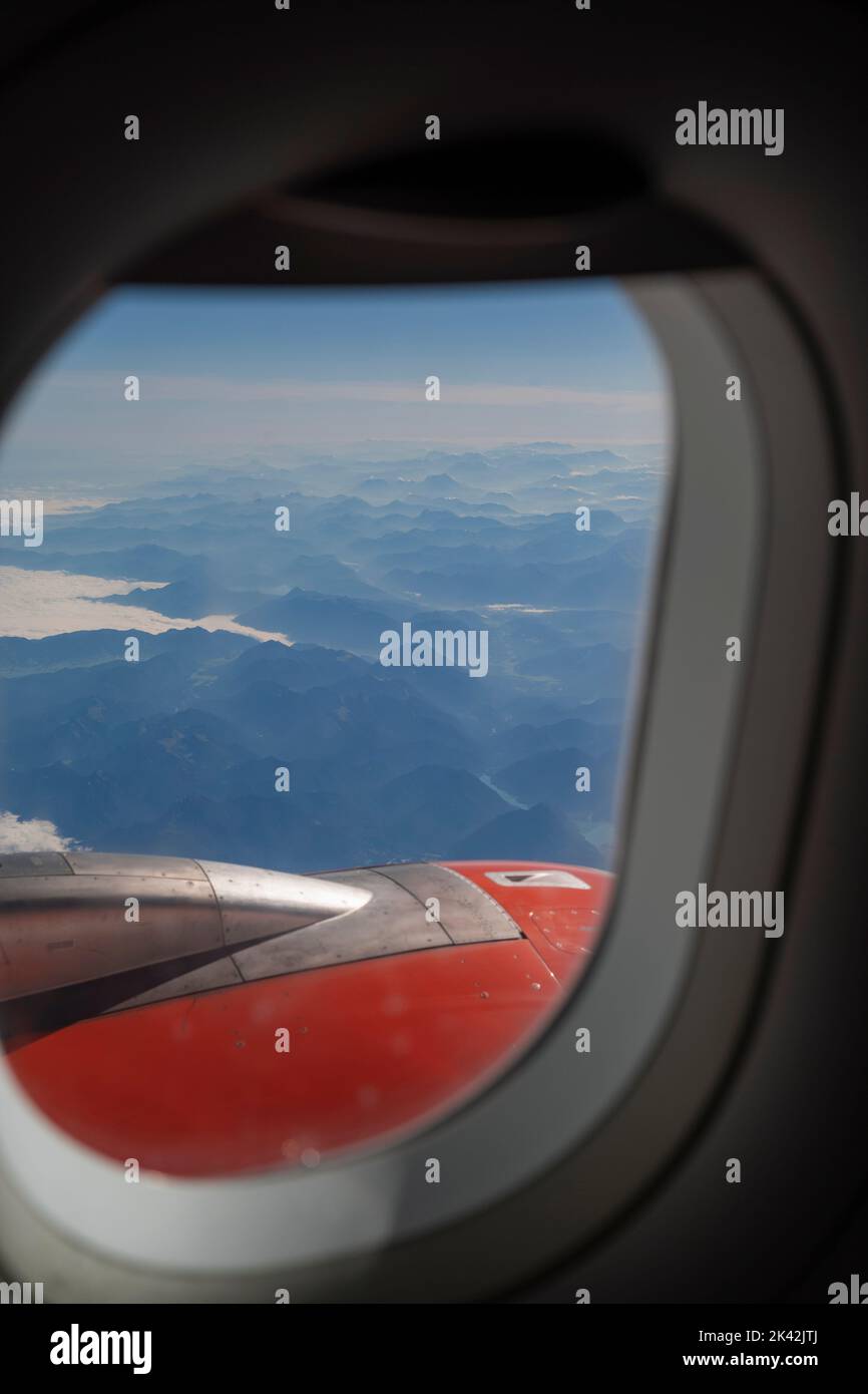 Vue sur les Alpes et le moteur à réaction par la fenêtre d'un avion Banque D'Images