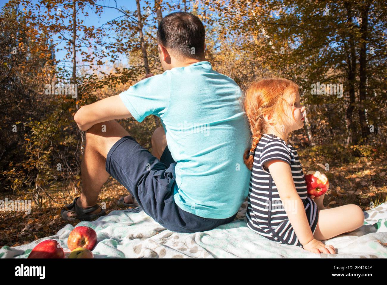 papa et fille sont assis dos à dos lors d'un pique-nique d'automne Banque D'Images