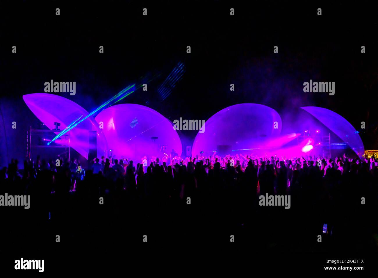 Des lumières laser colorées brillent et se déplacent sur la foule dansante pendant la fête du DJ Banque D'Images