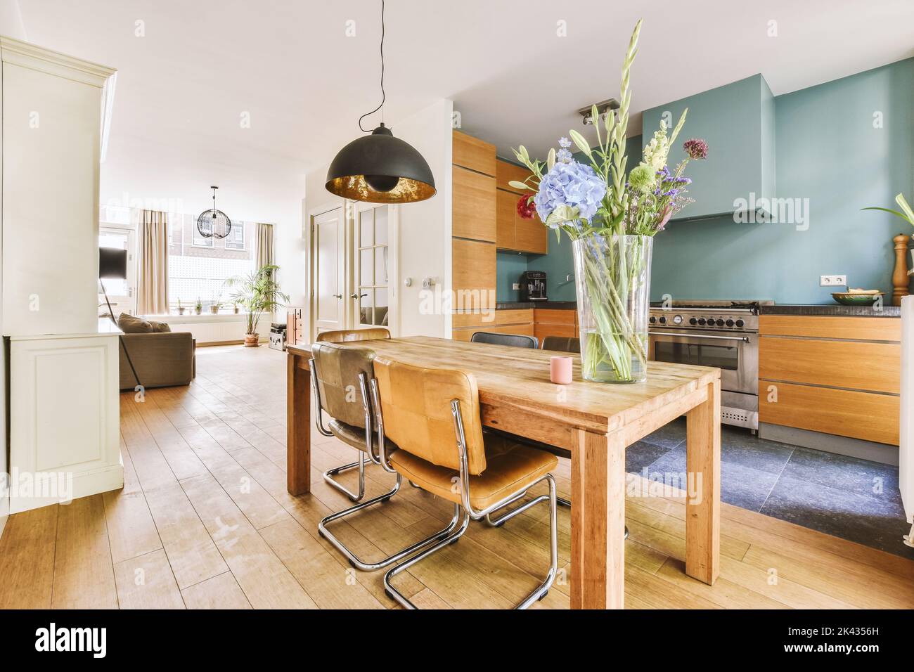 Décoration intérieure d'appartement loft moderne avec cuisine ouverte dans un style minimaliste et spacieuse salle à manger avec table et chaises Banque D'Images