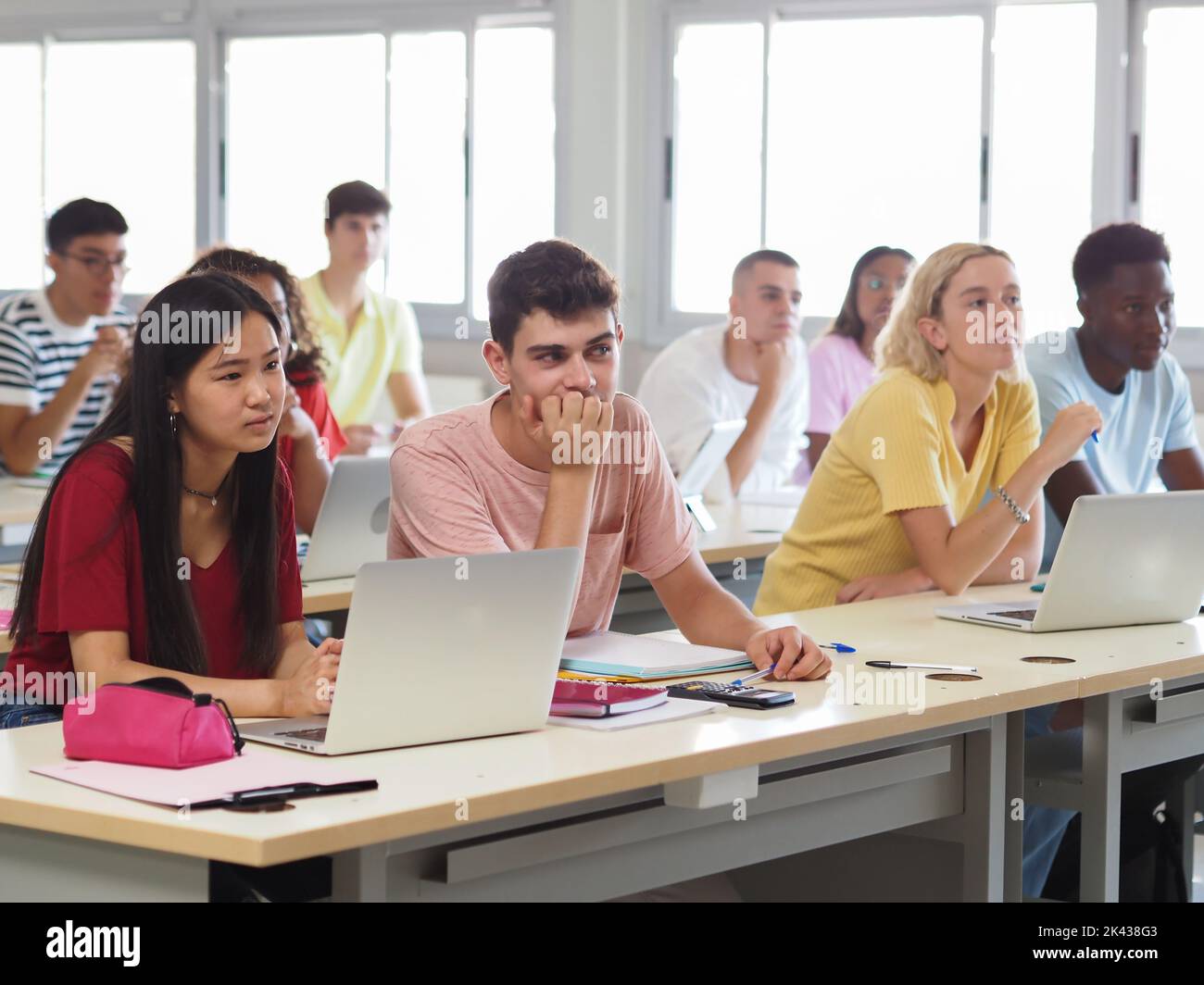 Groupe d'adolescents multiethniques écoutant la leçon en classe Banque D'Images